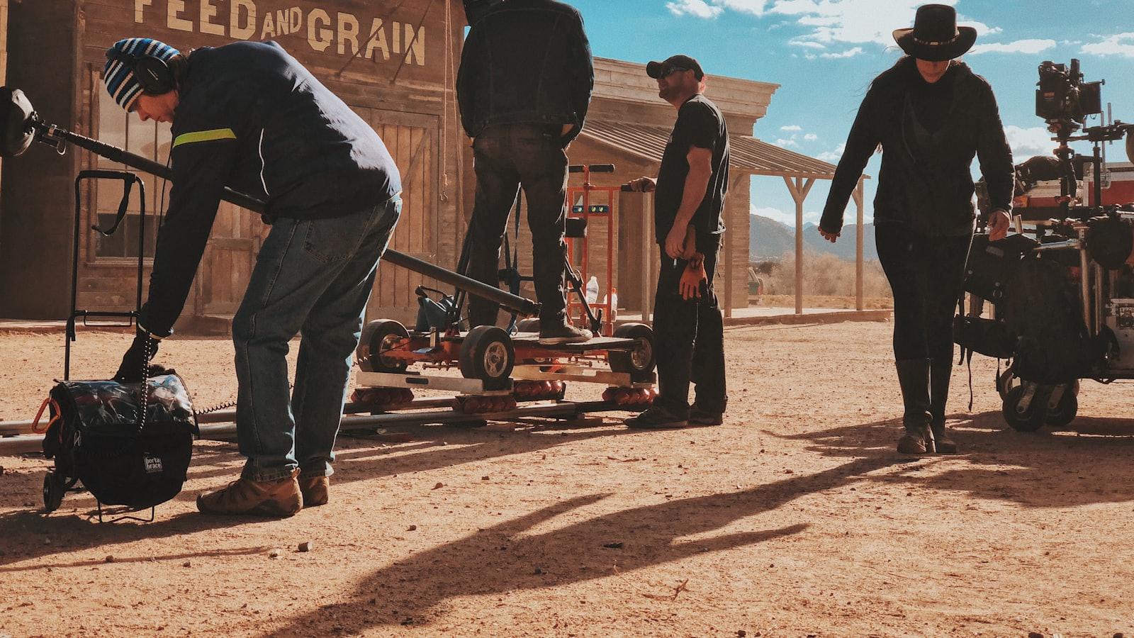 Equipe de cinema montando dolly e câmera em um set de curta-metragem ao ar livre.